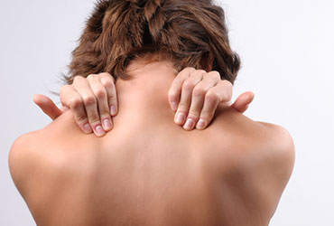 a woman holding her neck from pain