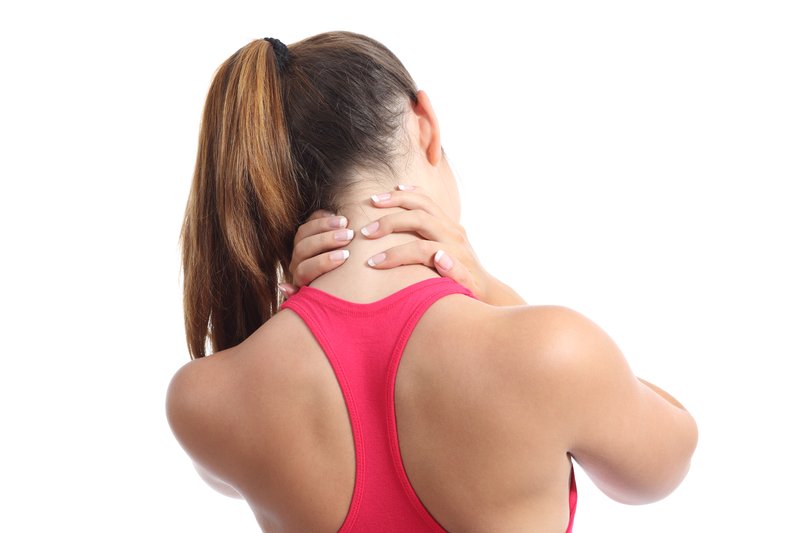 a woman in a pink shirt holding her neck with both hands