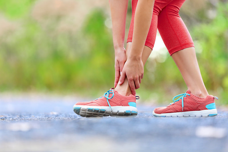 a woman holding her ankle from pain