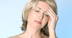 a woman holding hear forehead because of a tension headache