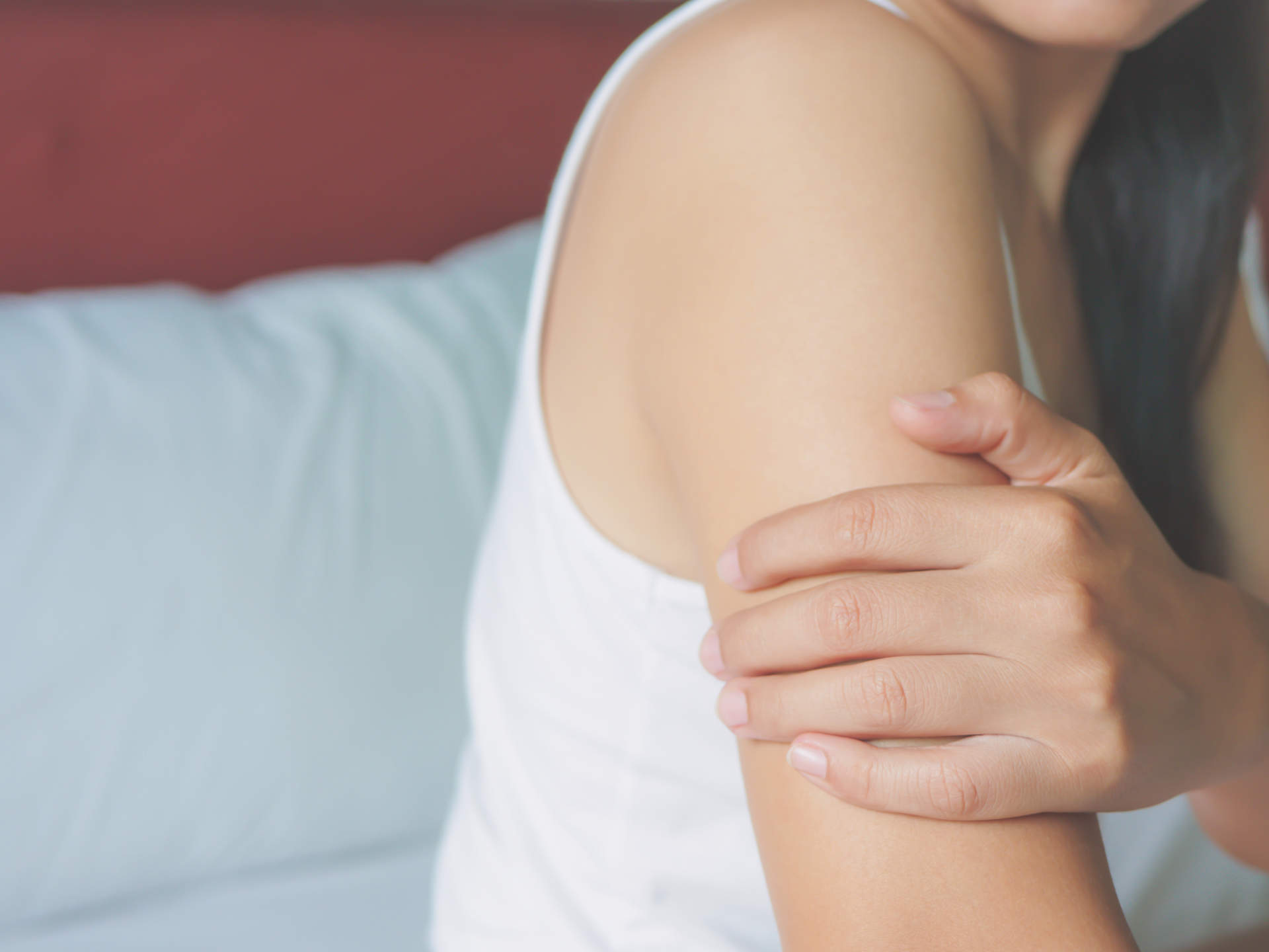 Unhappy woman suffering from painful feeling in arm muscle