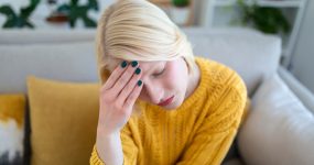 Sinus ache causing very paintful headache. Unhealthy woman in pain. Sharp strong sore. Sinus pain, sinus pressure, sinusitis. Sad woman holding her head because sinus pain