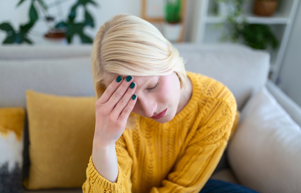 Sinus ache causing very paintful headache. Unhealthy woman in pain. Sharp strong sore. Sinus pain, sinus pressure, sinusitis. Sad woman holding her head because sinus pain